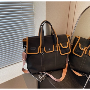Détail du sac cabas en toile avec surpiqûres contrastées, poches cargo et bandoulière