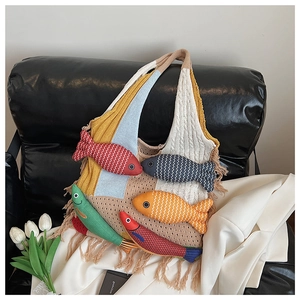 Close-up of colorful knitted fish patterns and tassels on a bohemian tote bag