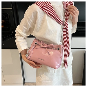 Detailed shot of pink patent leather shoulder bag with silver padlock and chain strap