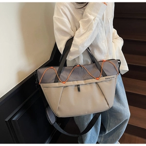Detail of grey grid tote with orange elastic cords and adjustable shoulder strap padding