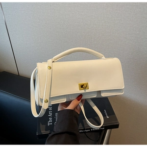 Detail of white square handbag showing matte PU leather texture and gold turn-lock closure
