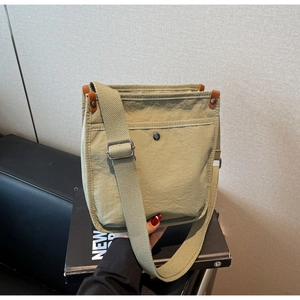 Dettaglio della borsa a tracolla in nylon verde oliva con dettagli in pelle marrone