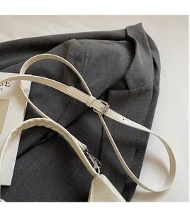 Détail de la bandoulière réglable en cuir crème avec boucle et crochet métalliques