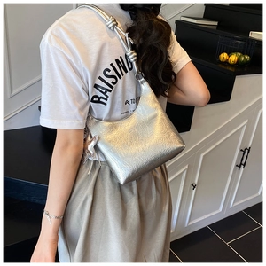 Sac à bandoulière argenté métallisé avec bandoulière nouée et breloque étoile sur modèle