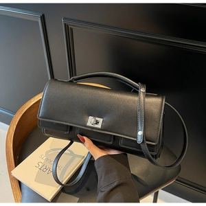 Detail of matte black leather handbag featuring silver metal twist lock and fine texture