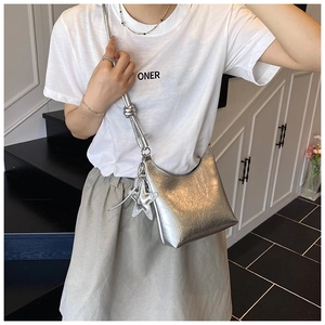 Détail du sac bandoulière argenté métallisé avec texture plissée et accessoire étoile
