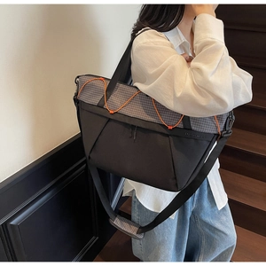 Detail shot of black sports tote bag with orange cords shown in a lifestyle staircase setting