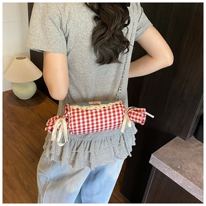 Detail of candy-shaped crossbody bag with red checkered fabric and denim finish