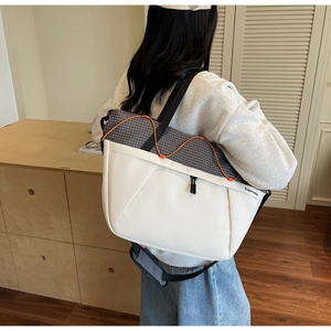 Detail of a large capacity sports bag featuring grey plaid nylon and orange drawstring cord