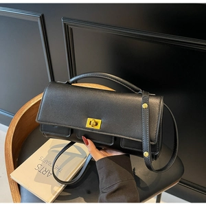 Close-up of black leather square bag with golden twist lock and front pockets