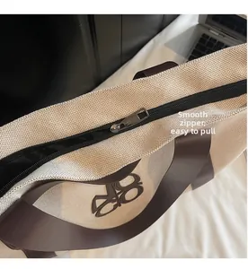Detail of smooth metal zipper closure on large canvas tote bag with leather trim