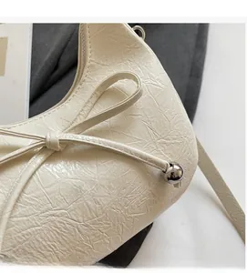 Gros plan sur la texture en cuir plissé avec nœud coulissant et perle en métal