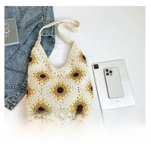 Detail showing hand-woven sunflower patterns on a cream crochet tote bag with daily items
