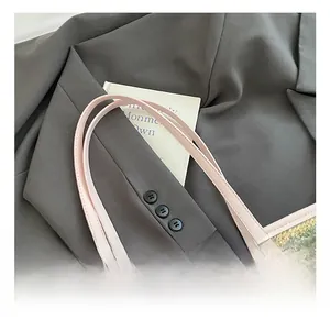 Detail of colorful woven straw tote with rainbow stripes and pink faux leather handles