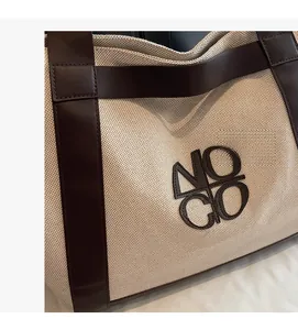 Close-up of thick canvas texture and brown leather trim on large tote handbag