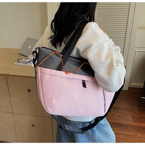 Detail of pink and grey patchwork tote bag featuring orange drawstring and wide shoulder strap