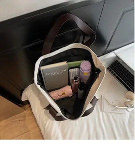 Top view of large canvas tote bag showing spacious interior with books and laptop