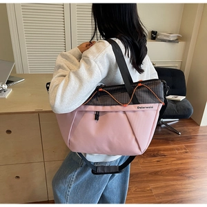Rear view of a model wearing the large pink and grey checkered tote with orange drawstring