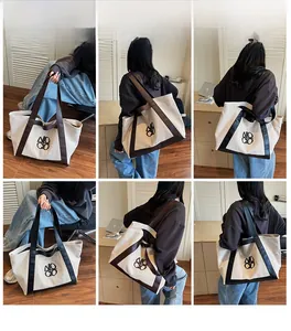 Detail view of large canvas tote bag with leather trim and shoulder straps on model