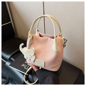 Macro detail of pink knit texture and off-white leather handles on a fashion bucket bag