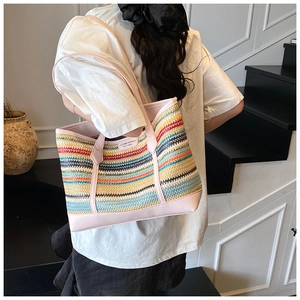 Detail of colorful striped straw tote bag with pink leather trim and brand patch