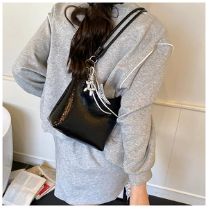 Sac hobo noir brillant avec pendentif chien ballon argenté et détail de pompon