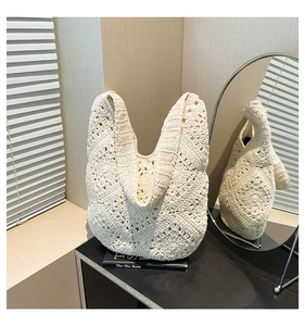 Detailed view of white hollow-out crochet pattern on a stylish summer woven shoulder bag
