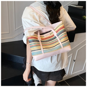 Detail view of the colorful striped straw tote bag showing large capacity and pink straps