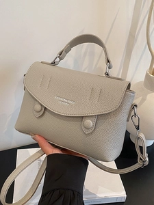 Minimalist grey lychee leather crossbody bag with top handle and adjustable strap