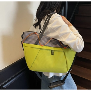 Detail of the Daier neon green and grey grid tote bag with orange bungee cord accent