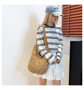 Detail of hollow-out diamond knit pattern on large khaki woven shoulder bag