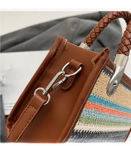 Detail of colorful woven handbag featuring premium leather trim and durable metal hooks