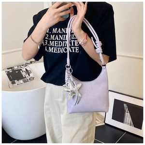 Détail du sac seau lilas avec breloque étoile de mer argentée et bandoulière à nœuds