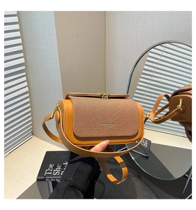Detail view of contrast stitching and gold metal buckle on a retro crossbody bag