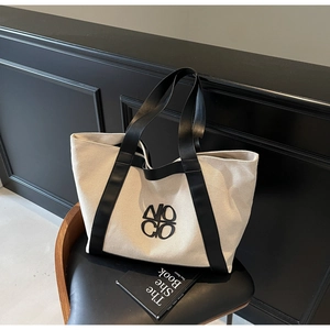 Detailed macro view of high-quality canvas fabric and leather handle on large tote bag