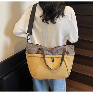 Detailed back view of a large two-tone canvas travel tote showing adjustable shoulder strap