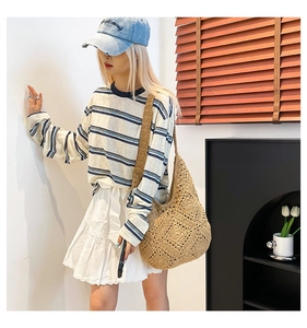 Detail of a large beige hand-woven crochet tote bag paired with a casual summer outfit