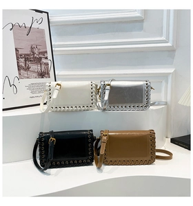 Detail view of woven leather edges on square shoulder bags in white, silver, black and tan