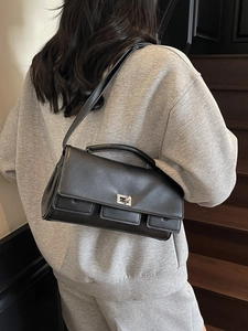 Minimalist black leather crossbody bag with silver buckle and multiple front pockets