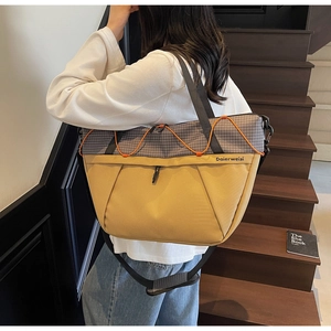 Detail of yellow and plaid tote bag with orange cords and a comfortable wide shoulder strap