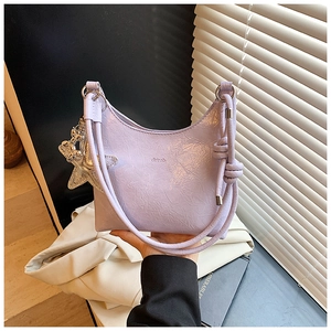 Détail du sac seau lavande avec texture plissée, breloque étoile et anneaux métalliques