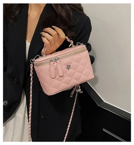 Détail du sac seau rose matelassé avec ornement camélia argenté et bandoulière