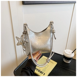 Gros plan du sac seau argenté plissé avec pendentif étoile et détail de nœud