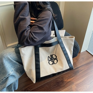 Detail of the high-quality canvas fabric and black leather trim on this tote bag