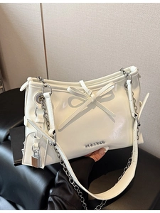 White glossy shoulder bag with chain strap and bow detail in a minimalist design