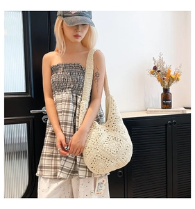 Detail of hand-woven cream crochet hobo shoulder bag with bohemian texture and style
