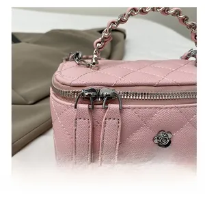 Détail du sac seau en cuir matelassé rose avec breloque fleur argentée et zip fluide