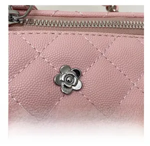 Détail du sac seau en cuir matelassé rose avec décoration de fleur de camélia argentée