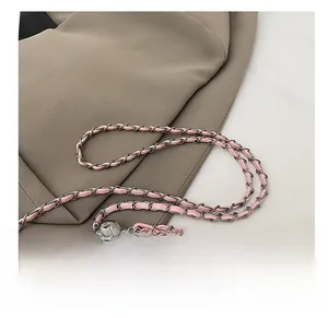 Détail de la chaîne tressée en cuir rose et métal gris avec une boucle boule ajustable