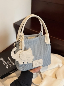 Light blue woven pattern crossbody bag with cream leather handle and elephant charm